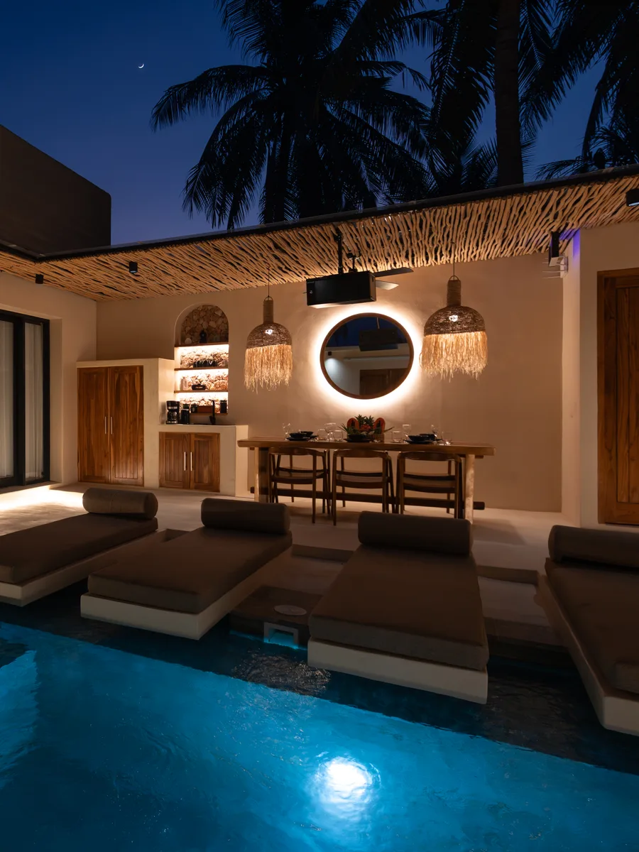 Villa courtyard and pool lit up at night